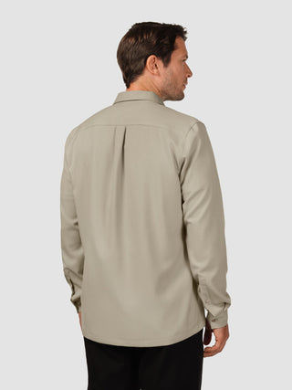Ein Mann von hinten, der ein „Effortless Shirt“ in der Farbe „Stone Beige“ trägt.