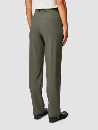 Rückansicht einer Person, die eine „Essential Pants Straight“ in Dunkeloliv und schwarze Stiefel trägt.