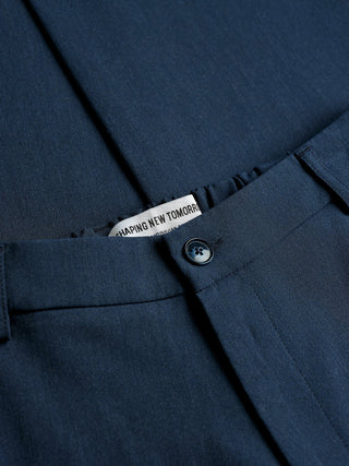 Nahaufnahme der „Essential Pants Relaxed Fit Navy Melange“ mit einem „Shaping New Tomorrow“-Markenlabel am Bund.