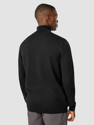 Ein Mann, von hinten gesehen, der einen schwarzen Rollkragenpullover von Everyday Knit trägt.