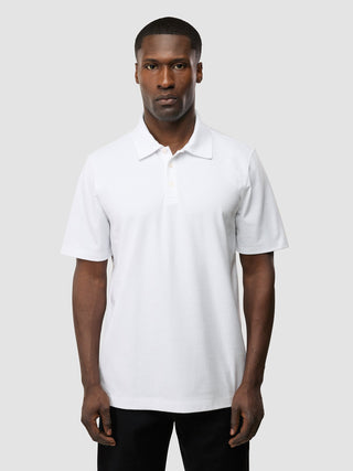 Ein Mann, der das „Evolve Pique Polo White“ trägt.