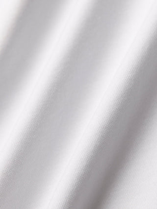 Evolve Pique Polo in Weiß mit weichen, diagonalen Falten.