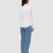 Eine Person, von hinten gesehen, die ein Damen-Oxford-Hemd White Orchid Slim und eine blaue Jeans trägt.