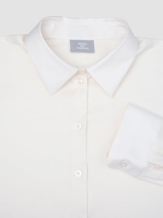 Cremefarbenes, langärmeliges Damen-Oxfordhemd White Orchid Slim mit klassischem Kragen und umgeschlagenen Manschetten im minimalistischen skandinavischen Design.