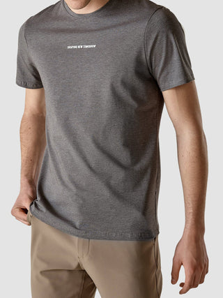 Eine Person, die ein dunkelgraues „Supima Autograph“-T-Shirt trägt, auf dessen Brust der Schriftzug „SHAPING NEW TOMORROW“ aufgedruckt ist.