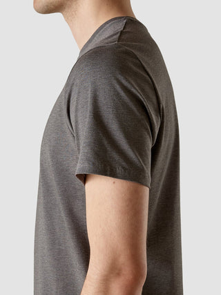 Eine Seitenansicht eines Mannes, der ein Supima Autograph T-Shirt in Dunkelgrau mit 360°-Stretch trägt.