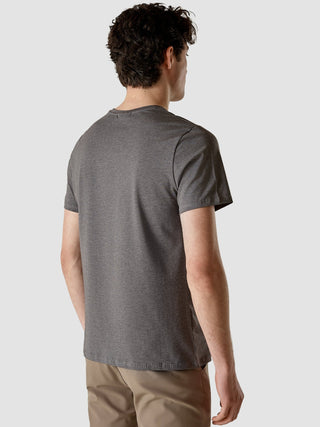 Ein Mann, von hinten gesehen, der ein dunkelgraues „Supima Autograph“-T-Shirt und eine hellbraune Hose mit 360°-Stretch trägt.