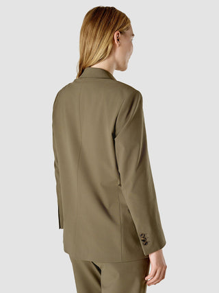 Eine Frau, von hinten gesehen, die den Blazer „Essential Suit Straight Dark Olive“ trägt.