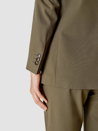 Nahaufnahme des Ärmels und der Tasche des Blazers „Essential Suit Straight Dark Olive“ und der dazu passenden Hose.