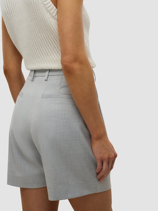 Eine Person, die das „Skye Set Grey Pine Melange“ aus langer Weste und Shorts im minimalistischen skandinavischen Design trägt.