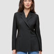 Eine Person, die einen schwarzen Avira-Blazer für Damen mit fallendem Revers und eine blaue Jeans trägt, die das minimalistische skandinavische Design unterstreichen.