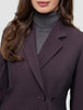 Eine Person trägt einen Avira-Blazer für Damen in der Farbe Burgundy Berry über einem grauen Rollkragenpullover und präsentiert damit eine klare, skandinavische Designästhetik.