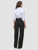 Eine Frau, von hinten gesehen, die ein weißes Hemd und eine schwarze Avira Pants Wide Black für Damen trägt.