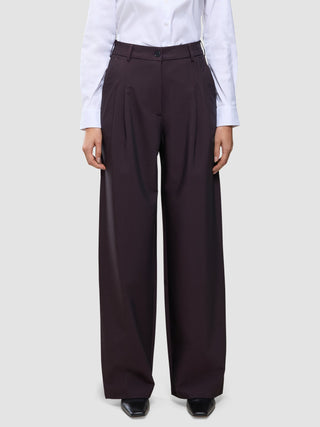 Die hoch taillierte Damenhose Avira mit weitem Bein in der Farbe Wide Burgundy Berry, kombiniert mit einem weißen Hemd.