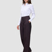 Eine Frau, die ein weißes Hemd trägt, das in die Damenhose Avira Pants Wide in der Farbe Burgundy Berry gesteckt ist.