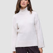 Frau in einem cremefarbenen, grob gestrickten Rollkragenpullover aus weicher Wolle: Damen-Rollkragenpullover aus grob gestrickter, weicher Wolle, Sugar Melange.