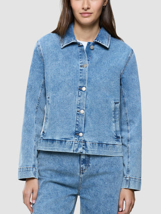 Eine Person, die eine klassische Damen-Jeansjacke in der Farbe „Snow Blue Wash“ trägt.