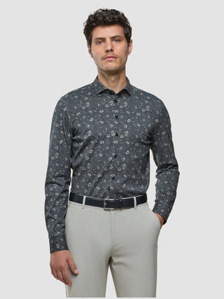 Ein Mann, der ein graues Classic-Hemd mit Blumenmuster in Regular-Passform, einen schwarzen Gürtel und eine helle Hose trägt.