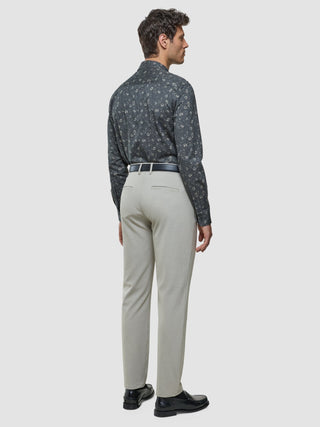 Ein Mann im Profil, der ein graues Classic-Hemd mit Blumenmuster in regulärer Passform trägt, dazu eine hellgraue Hose und schwarze Loafer.