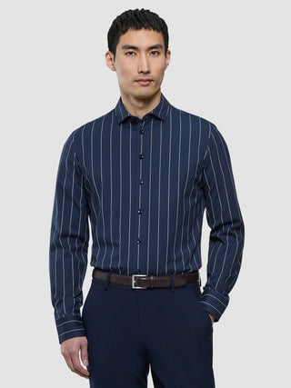 Ein Mann, der ein „Classic Shirt Midnight Pinstripes Regular“ und eine dunkle Hose trägt.