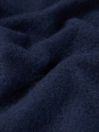 Nahaufnahme eines doppellagigen Woll-Overshirts in der Farbe Regular Dark Navy, die den marineblauen Stoff in tiefen, doppellagigen Falten zeigt.