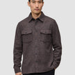 Ein Mann trägt ein doppellagiges Woll-Overshirt in Sattelbraun, das sich durch ein doppellagiges Design, zwei Brusttaschen und einen klassischen skandinavischen Stil auszeichnet.