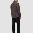 Ein Mann im Profil trägt ein doppellagiges Wollhemd in Sattelbraun über einer schwarzen Hose und schwarzen Loafern.