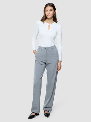 Eine Frau, die einen weißen, langärmeligen Pullover mit Schlüssellochausschnitt und eine „Women Ease Pants Straight Steel Melange“ trägt.