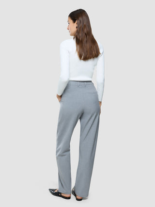 Eine Frau, von hinten gesehen, die ein weißes, langärmeliges, geripptes Oberteil und eine „Women Ease Pants Straight Steel Melange“ trägt.