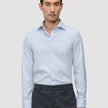 Ein Mann, der ein Elevated Shirt Regular Classic Blue Striped mit hellblauen und weißen Streifen trägt, kombiniert mit einer dunkelgrauen Hose.