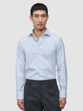 Ein Mann, der ein Elevated Shirt Regular Classic Blue Striped mit hellblauen und weißen Streifen trägt, kombiniert mit einer dunkelgrauen Hose.