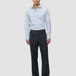 Ein Mann, der ein hellblau gestreiftes Hemd der Marke Elevated im Modell Regular Classic Blue Striped sowie eine dunkelgraue Hose trägt.
