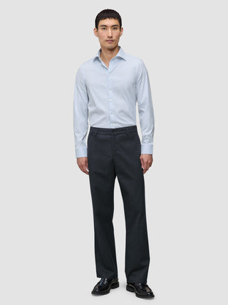 Ein Mann, der ein hellblau gestreiftes Hemd der Marke Elevated im Modell Regular Classic Blue Striped sowie eine dunkelgraue Hose trägt.