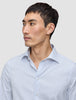 Ein Mann, der ein Elevated Shirt Regular Classic Blue Striped aus hellblau-weiß gestreifter Pima-Baumwolle trägt.