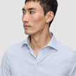 Ein Mann, der ein Elevated Shirt Regular Classic Blue Striped aus hellblau-weiß gestreifter Pima-Baumwolle trägt.