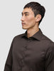 Ein Mann, der ein Elevated Shirt Slim Dark Brown trägt, ein dunkelbraunes, schmal geschnittenes Hemd mit Knöpfen.