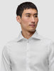 Eine Person, die ein Elevated Shirt White Slim trägt, ein knackig sitzendes, schmal geschnittenes weißes Hemd aus Pima-Baumwolle mit einem Spread-Kragen.