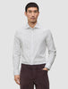 Ein Mann, der ein Elevated Shirt Slim Light Grey Striped trägt, ein schmal geschnittenes, langärmeliges Button-Down-Hemd aus Pima-Baumwolle mit vertikalen Streifen, sowie eine dunkle Hose.