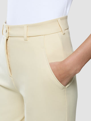 Nahaufnahme einer Person, die eine „Women Essential Pants Tapered“ in der Farbe „Misty Yellow“ trägt und die Hand in der Tasche hat.