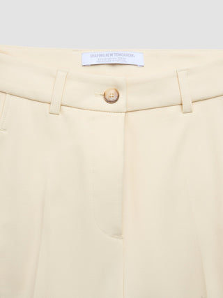 Cremefarbene Damenhose „Essential“ in schmal zulaufender Passform in Misty Yellow mit Knopfverschluss und einem „Shaping New Tomorrow“-Markenlabel am Bund.