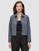 Eine Frau, die eine Essential Short Zip Jacket in Dunkelgrau-Melange über einem schwarzen Oberteil und einer schwarzen Hose trägt.