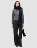 Eine Frau, die eine Essential Short Zip Jacket in Dunkelgrau-Melange, einen schwarzen Schal und eine schwarze Hose trägt und eine schwarze Handtasche bei sich hat.