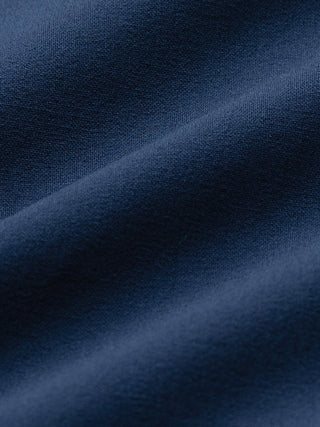 Nahaufnahme der „Essential“-Anzughose in lockerer Passform, marineblau, aus 360°-Stretch-Material mit dezenten Falten.