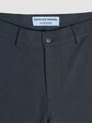 Nahaufnahme der „Gen. 2.0 Pants Regular Signature Dark Grey“ mit einem „Shaping New Tomorrow“-Markenlabel und einem Knopfverschluss mit dezenter Twill-Struktur.