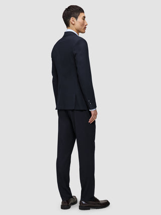 Ein Mann, von hinten gesehen, der den Motion Blazer Regular in Mitternachtsblau und eine dazu passende Hose im skandinavischen Design trägt.