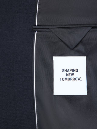 Im Inneren eines dunkelblauen Motion Blazer Regular Midnight Blue mit 360°-Stretch, der mit einem weißen Etikett mit der Aufschrift SHAPING NEW TOMORROW versehen ist.