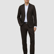Ein Mann in einem Motion Blazer Slim Cognac, einem weißen Hemd und schwarzen Anzugschuhen, die das klassische skandinavische Design widerspiegeln.