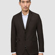 Ein Mann, der einen Motion Blazer Slim Cognac mit skandinavischem Design über einem weißen Hemd trägt.