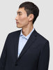 Ein Mann im Profil, der einen Motion Blazer Slim in Mitternachtsblau über einem hellblauen, Nadelstreifenhemd trägt.