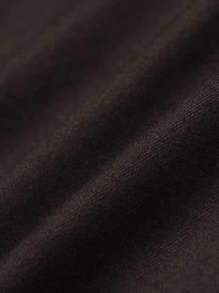 Nahaufnahme des gefalteten dunkelbraunen Stoffes der Motion Suit Pants Regular Cognac für einen eleganten Look.